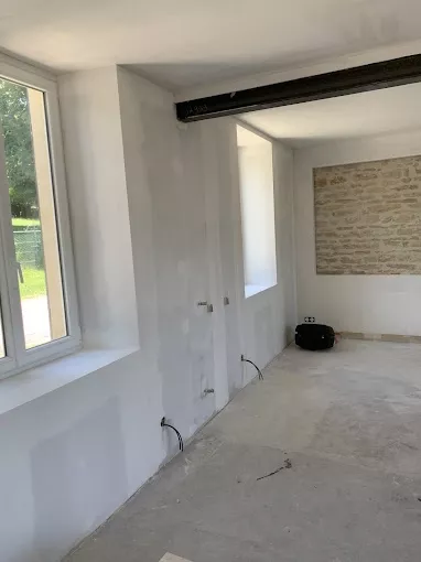 Pièce rénovée avec murs lissés et préparés avant peinture et finitions intérieures