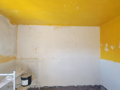 Préparation des murs de cuisine avant peinture lors de travaux de rénovation intérieure