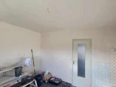 Cuisine en cours de rénovation avec murs préparés et surfaces avant mise en peinture