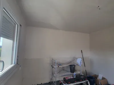 Travaux de rénovation intérieure avec murs enduits et préparation peinture dans une cuisine