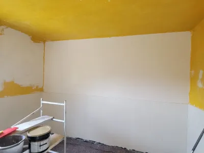 Mur intérieur rénové dans une cuisine avec enduit uniforme avant mise en peinture